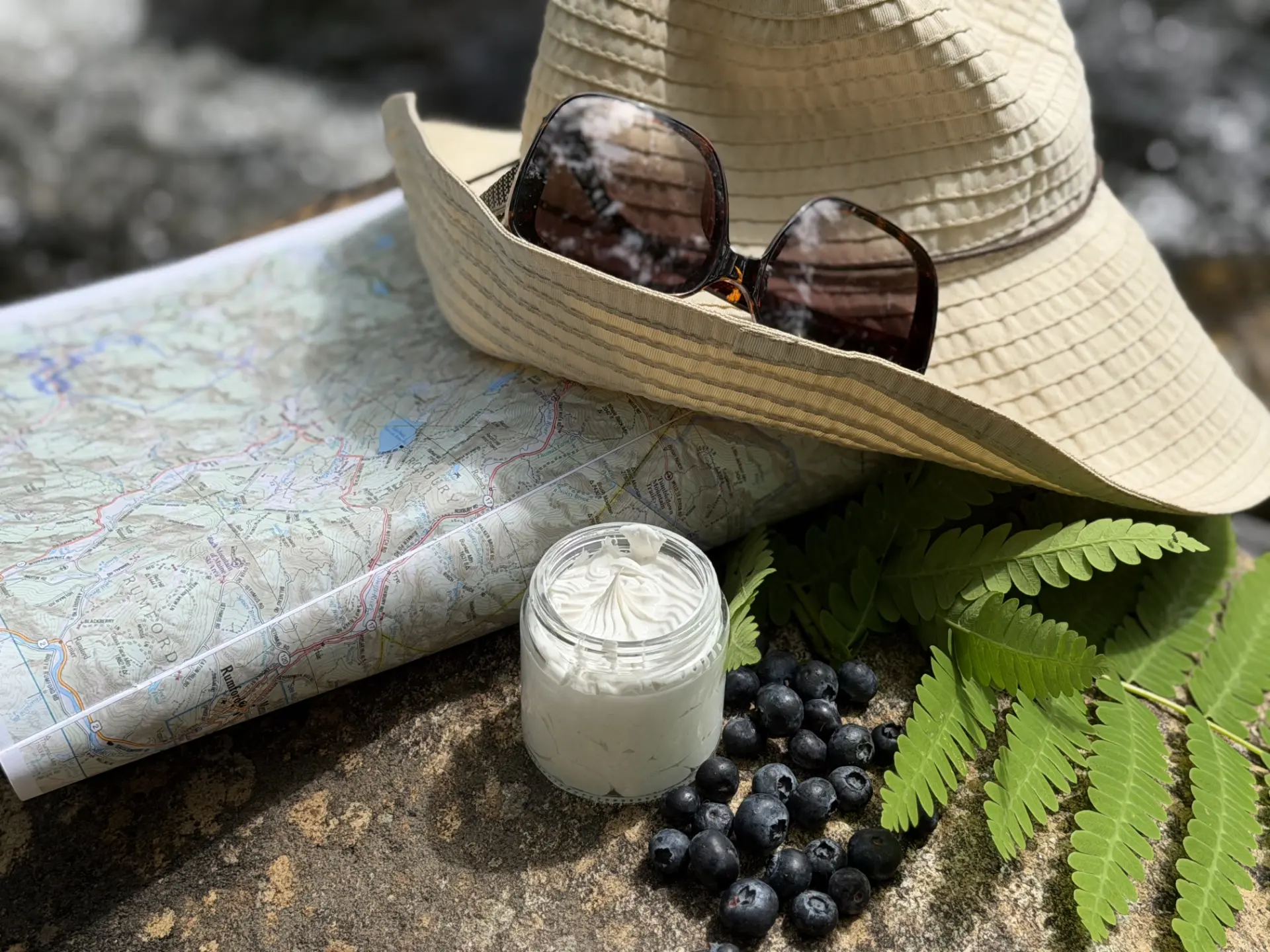 Trailmen's Tallow Sun Balm jar on a rock with outdoor gear